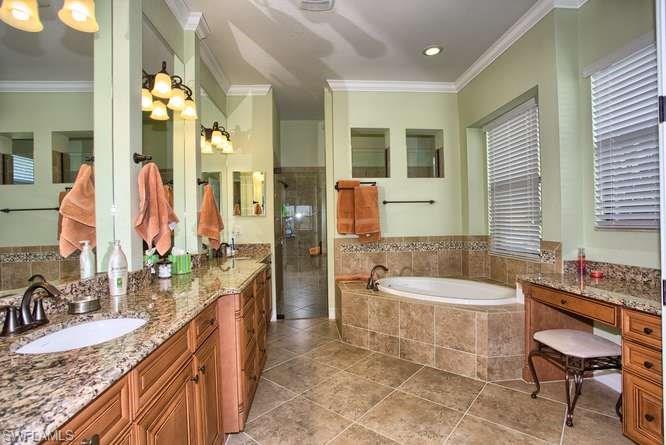 9633 Firenze Circle Naples, FL 34113 - Photo 17 of 25 a spacious bathroom with a granite countertop tub sink and mirror