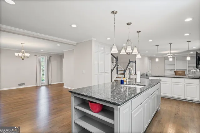 a kitchen with stainless steel appliances granite countertop a sink a refrigerator and a stove top oven