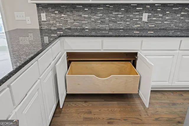 a view of empty room with wooden floor and cabinet