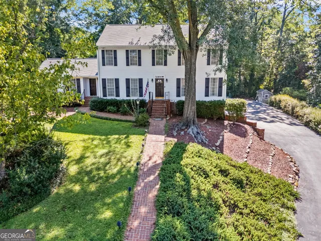 a front view of a residential houses with yard and green space