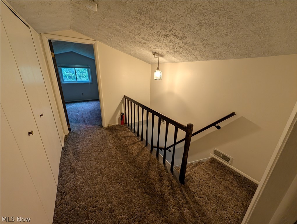 5205 Blair Road Perry, OH 44081 - Photo 8 of 10 Upper-level landing featuring textured carpeting, a dark wood newel post and balusters, and a complementary handrail