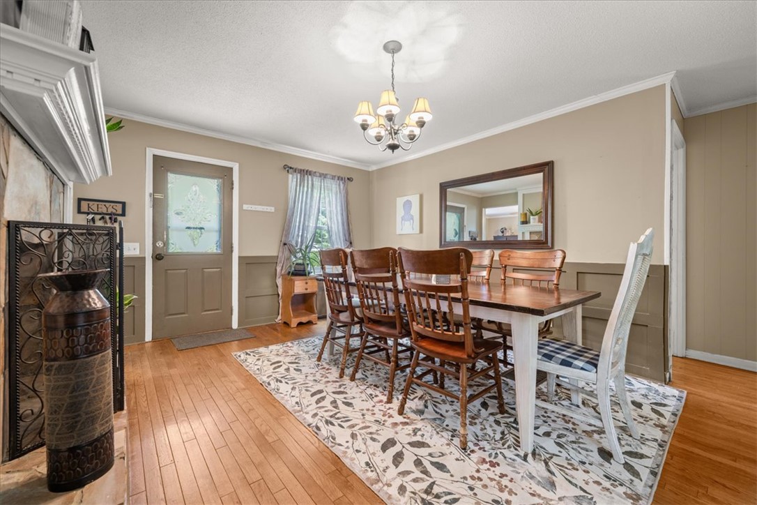 668 Marcengill Road Westminster, SC 29693 - Photo 8 of 37 A classic dining area boasts rich hardwood floors and a tasteful overhead chandelier, creating an inviting atmosphere.
