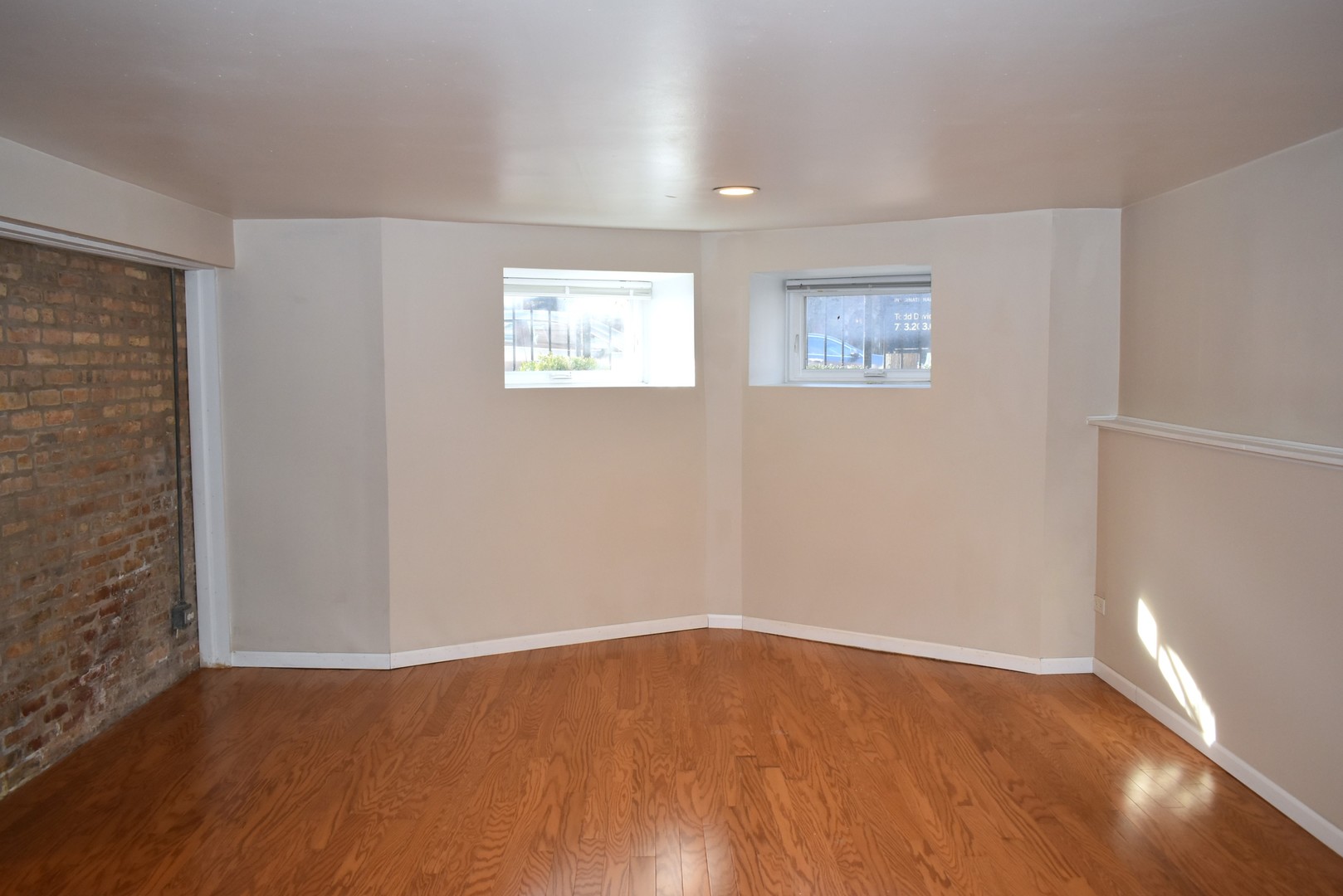 4633 North Racine Avenue, Unit GN Chicago, IL 60640 - Photo 5 of 25 a view of an empty room with wooden floor and a window