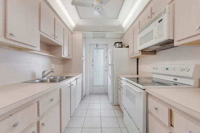 a kitchen with a sink dishwasher stove and cabinets
