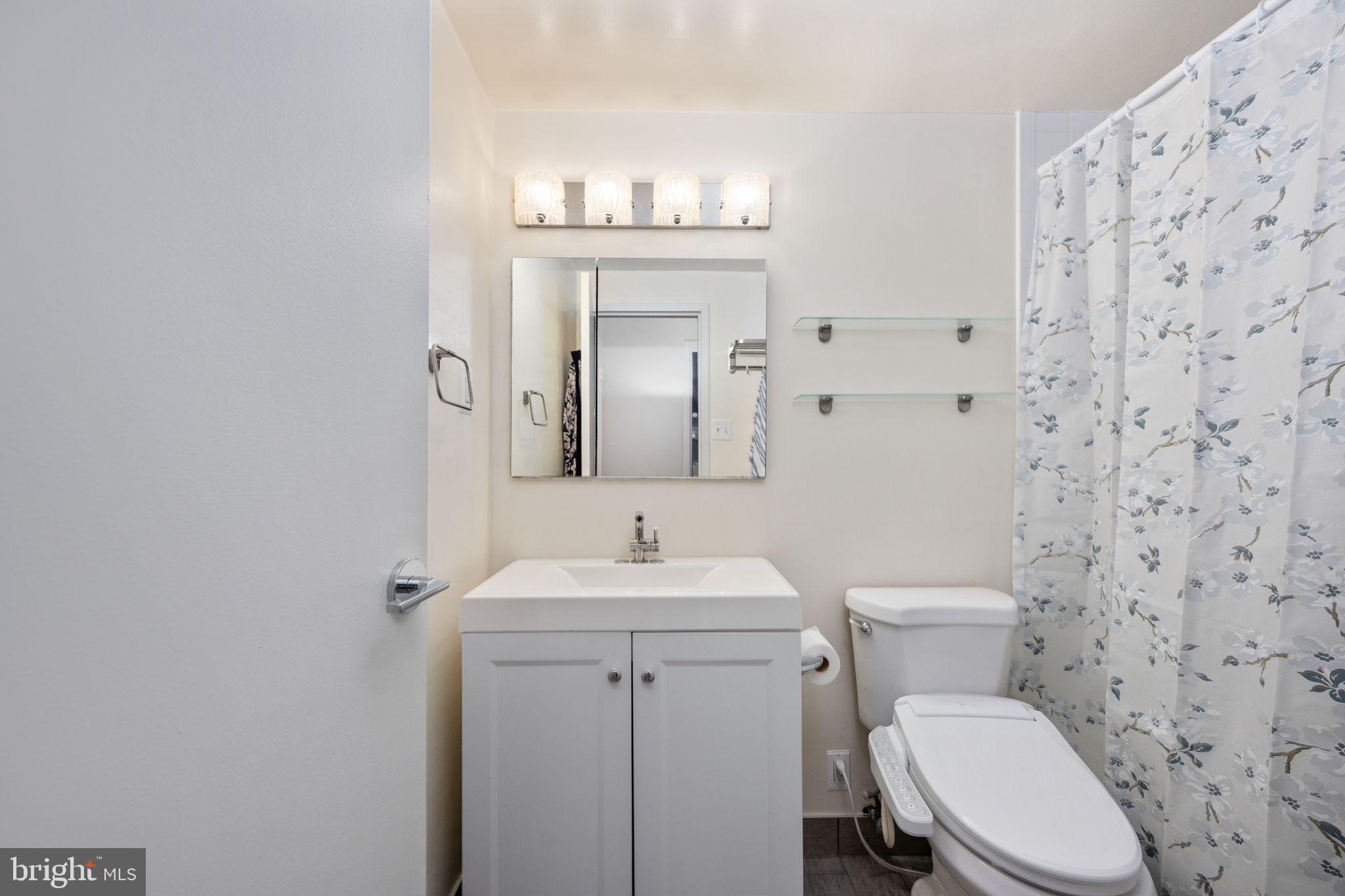 4141 North Henderson Road, Unit 702 Arlington, VA 22203 - Photo 37 of 69 a bathroom with a toilet sink vanity and mirror