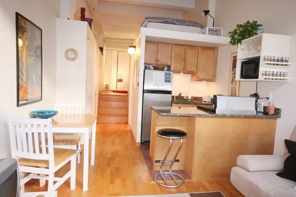 a kitchen with stainless steel appliances kitchen island granite countertop a table and chairs in it