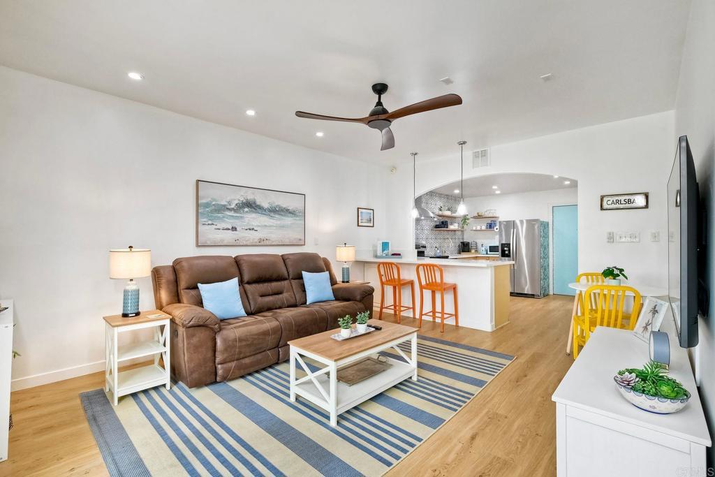 A bright and inviting open-concept living space with coastal charm, featuring a cozy sofa