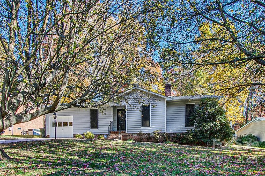 a front view of house with yard and trees in the background