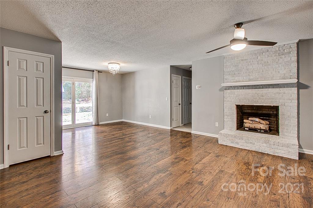 928 Meadowbrook Road Asheboro, NC 27203 - Photo 4 of 25 a view of an empty room with wooden floor fireplace and a window