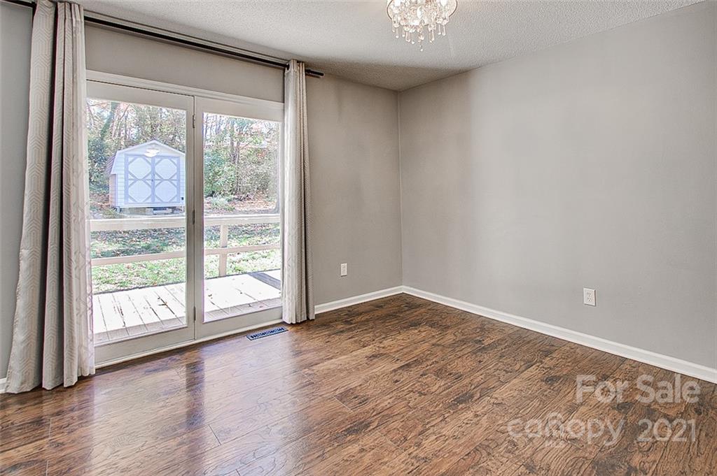 928 Meadowbrook Road Asheboro, NC 27203 - Photo 6 of 25 a view of an empty room with wooden floor and a window