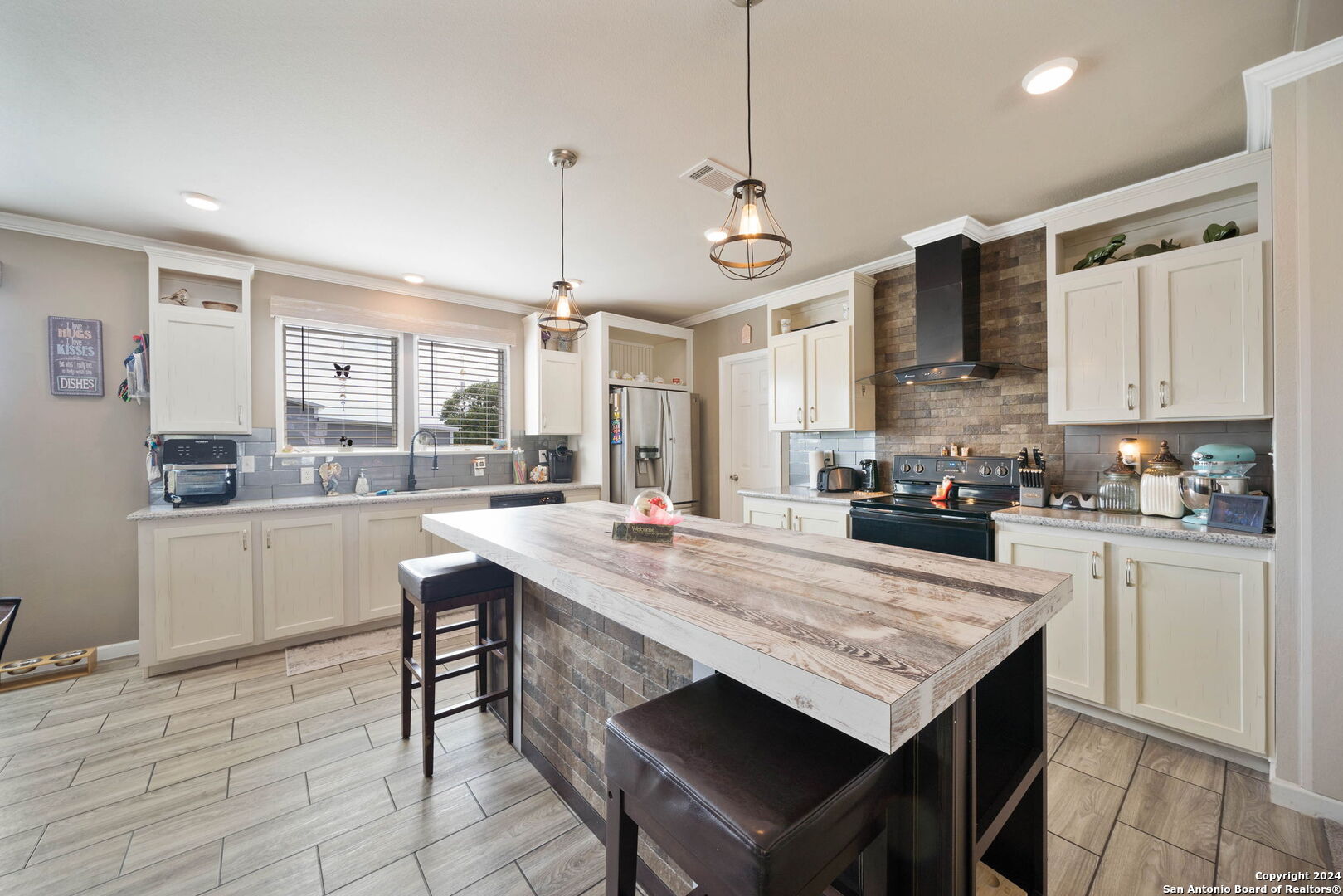 a kitchen with granite countertop a stove a sink dishwasher a refrigerator and white cabinets with wooden floor