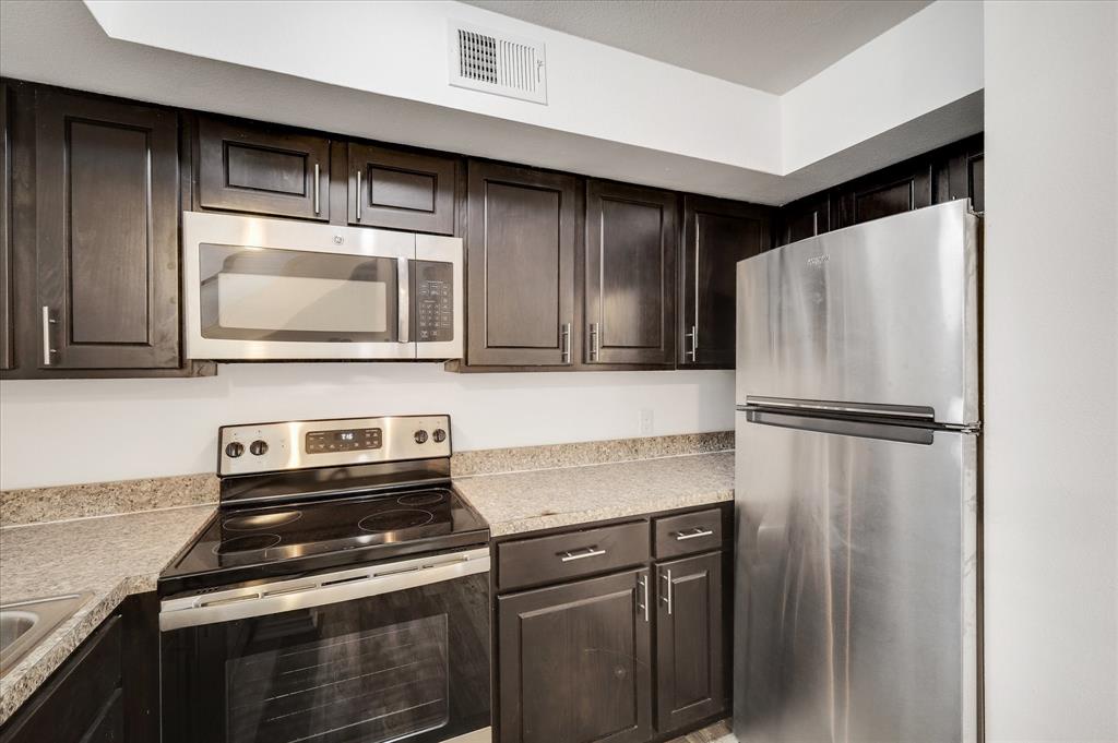 9831 Walnut Street, Unit 212 Dallas, TX 75243 - Photo 12 of 27 Kitchen featuring sink, dark brown cabinets, and appliances with stainless steel finishes