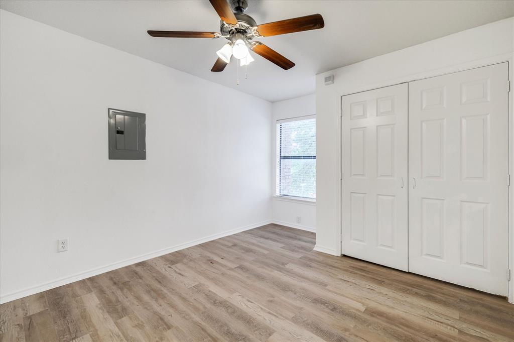 9831 Walnut Street, Unit 212 Dallas, TX 75243 - Photo 13 of 27 Unfurnished bedroom with ceiling fan, a closet, electric panel, and light hardwood / wood-style flooring