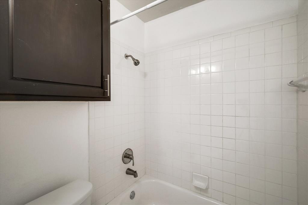 9831 Walnut Street, Unit 212 Dallas, TX 75243 - Photo 23 of 27 Bathroom featuring toilet and tiled shower / bath