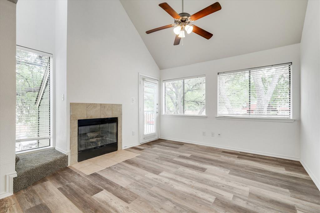 9831 Walnut Street, Unit 212 Dallas, TX 75243 - Photo 5 of 27 Unfurnished living room with a healthy amount of sunlight, light wood-type flooring, and high vaulted ceiling