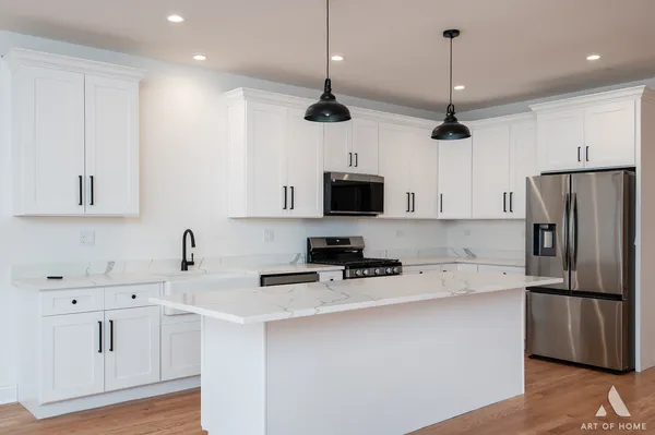 a kitchen with stainless steel appliances granite countertop a sink a stove and microwave