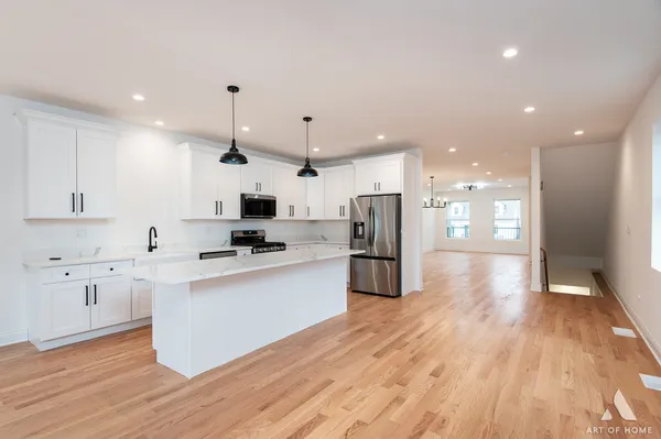 a kitchen with a sink chandelier and wooden floor