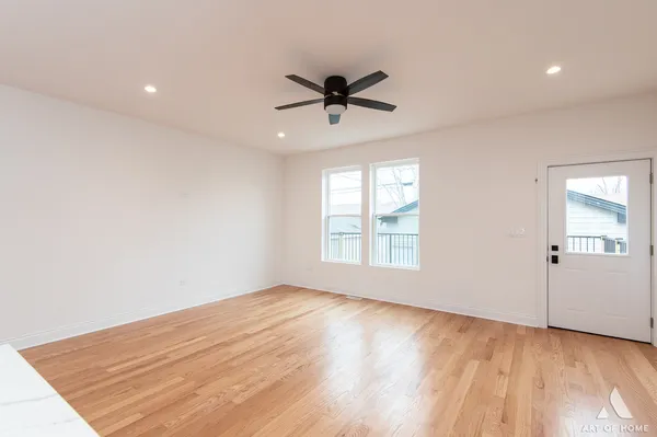 a view of an empty room and window and wooden floor