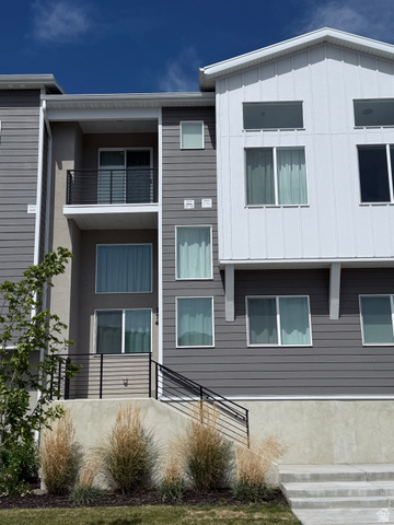 774 West 480 South American Fork, UT 84003 - Photo 2 of 76 Contemporary multi-level exterior with a striking gray and white facade, accented by black railings
