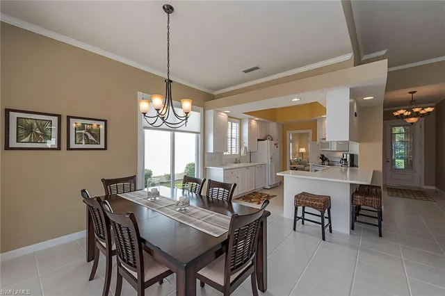 a dining room with furniture a chandelier and window