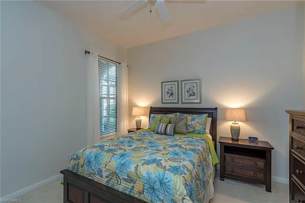 a bedroom with a bed and a lamp on dresser