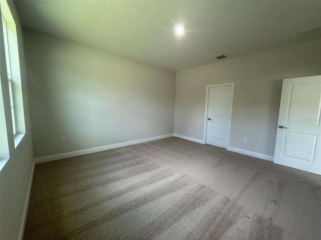 12132 Cattleside Drive Riverview, FL 33579 - Photo 21 of 31 an empty room with wooden floor and windows