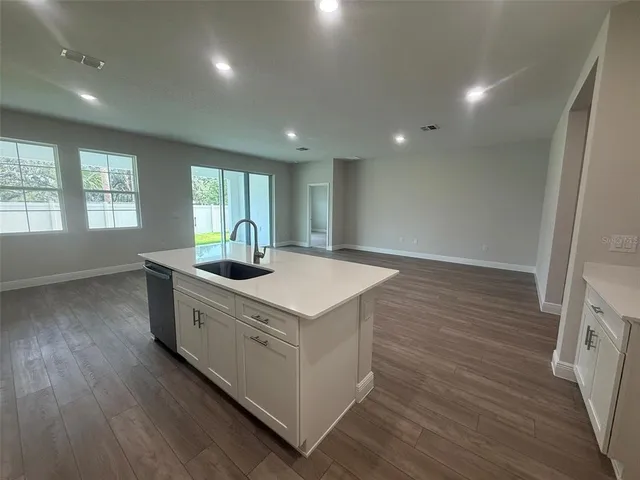a view of kitchen with sink and refrigerator