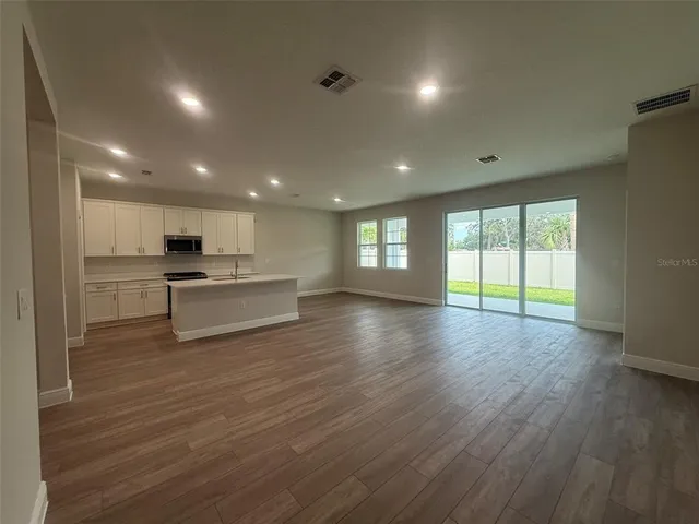 a view of kitchen with kitchen island wooden floor wooden floor and refrigerator