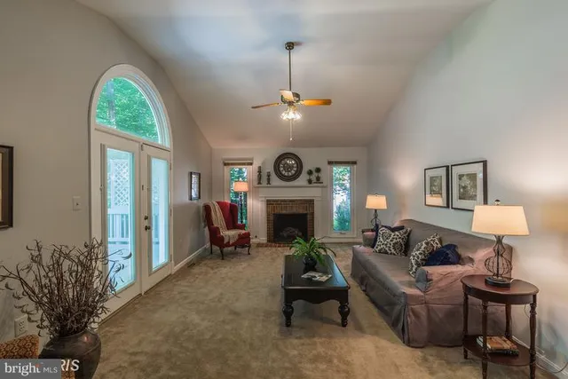 a living room with furniture a fireplace and a chandelier