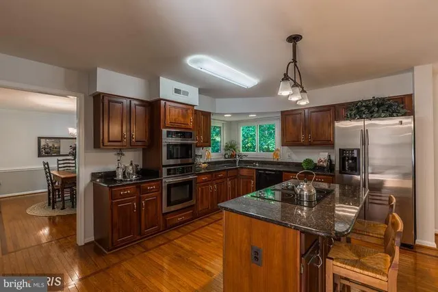 a kitchen with stainless steel appliances granite countertop a sink refrigerator and microwave