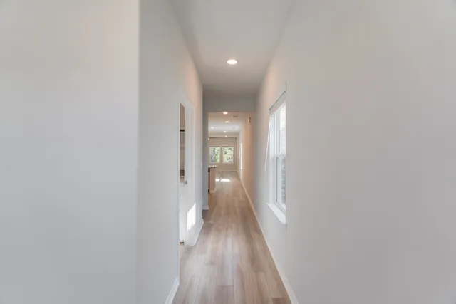 a view of a hallway with wooden floor