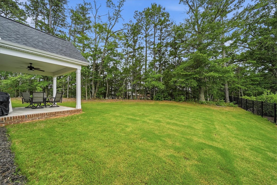 214 Timothy Court Anderson, SC 29621 - Photo 36 of 43 A spacious lawn unfolds from a covered patio, leading to a private, tree-lined perimeter.