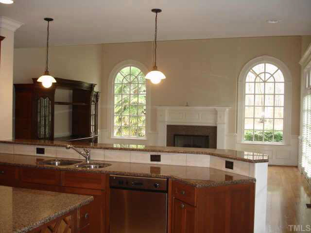 1412 Ridge Side Place Raleigh, NC 27613 - Photo 4 of 10 Open kitchen to spacious family room w/ tall ceilings, lots of light, hardwood floors, fireplace, opens to patio Other