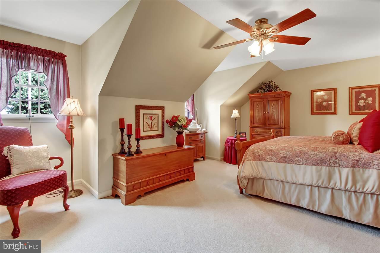 5650 Lischeys Church Road Spring Grove, PA 17362 - Photo 24 of 36 a spacious bedroom with a bed and a chandelier