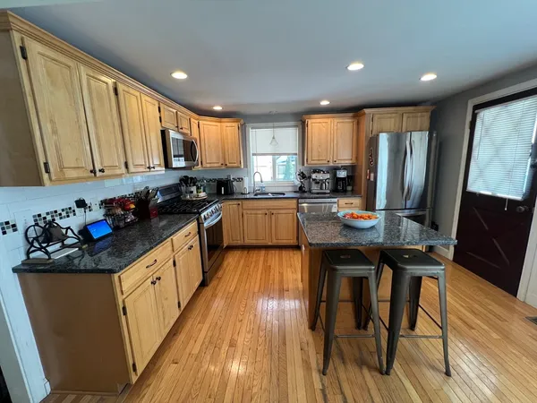 a kitchen with stainless steel appliances granite countertop a stove a sink and a microwave