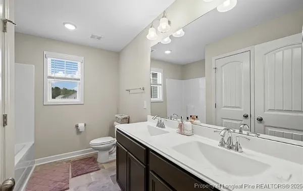 a bathroom with a toilet a sink and mirror