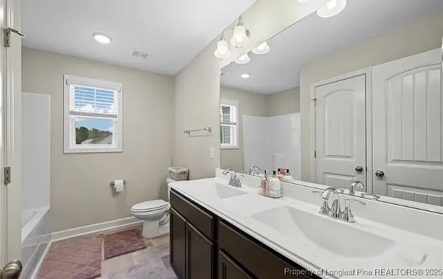 a bathroom with a toilet a sink and mirror