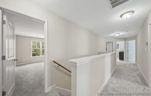 a view of a hallway with wooden floor and staircase