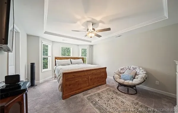 a spacious bedroom with a bed and a chandelier