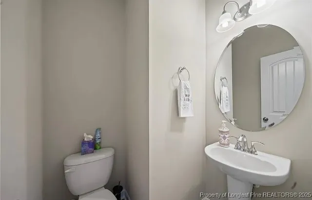 a bathroom with a toilet sink and mirror