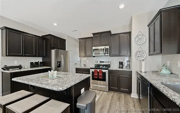 a kitchen with granite countertop a sink stove and refrigerator