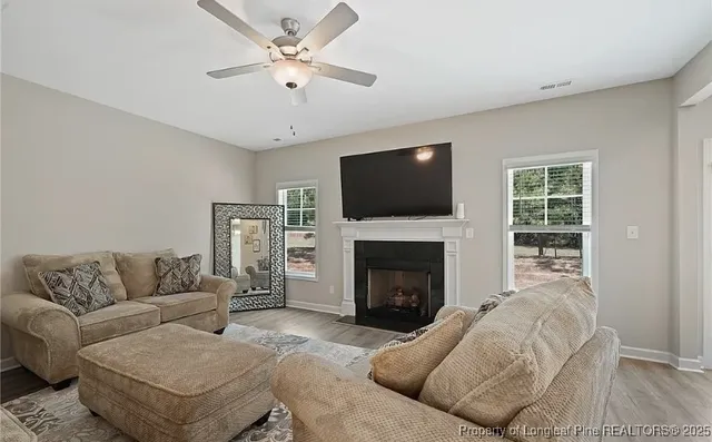 a living room with furniture a flat screen tv and a fireplace
