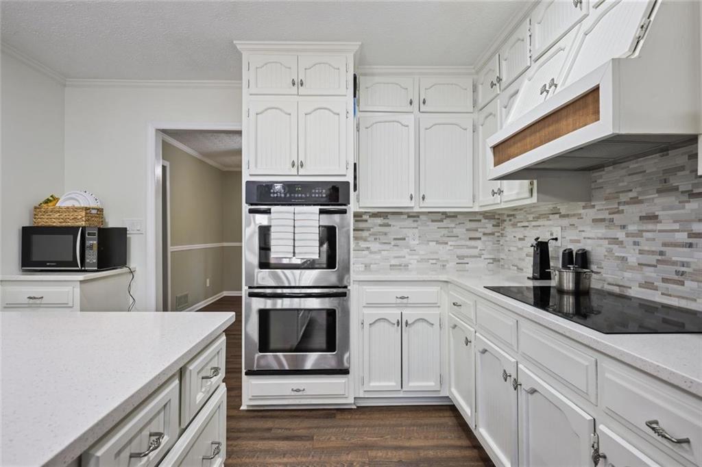 4505 Cochran Mill Road Fairburn, GA 30213 - Photo 16 of 36 a kitchen with cabinets stainless steel appliances and wooden floor