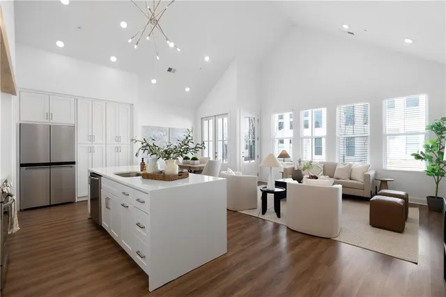 a living room with stainless steel appliances furniture and a large window