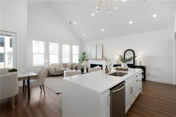a large white kitchen with sink a window and dining table chair