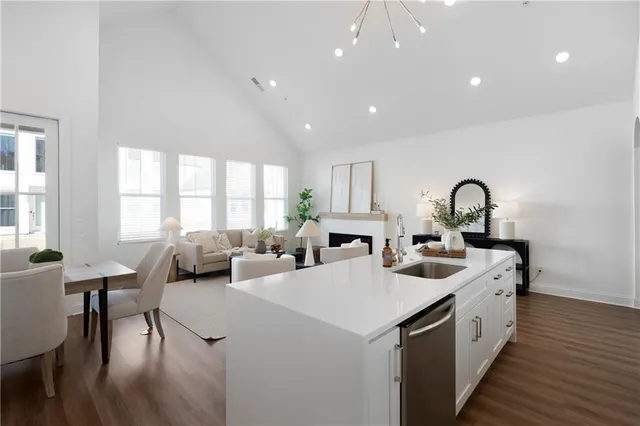 a large white kitchen with sink a window and dining table chair