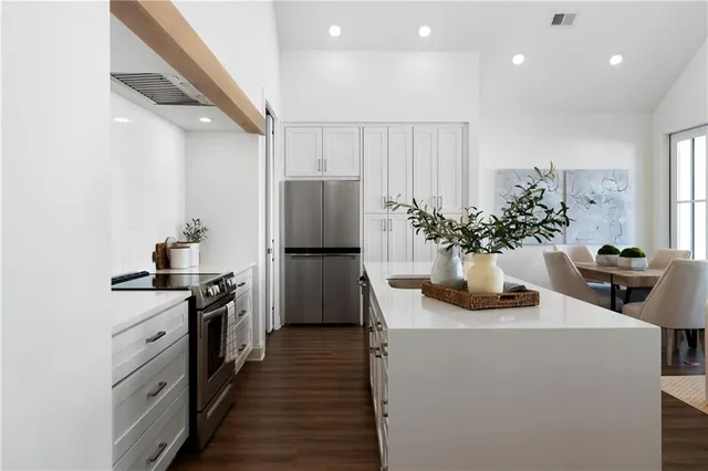 a kitchen with sink a refrigerator and microwave