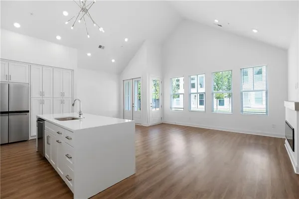 a view of a kitchen center island wooden floor and stainless steel appliances