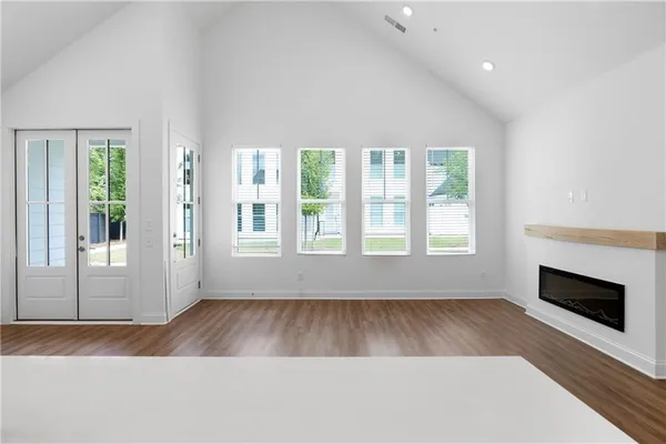an empty room with wooden floor and windows