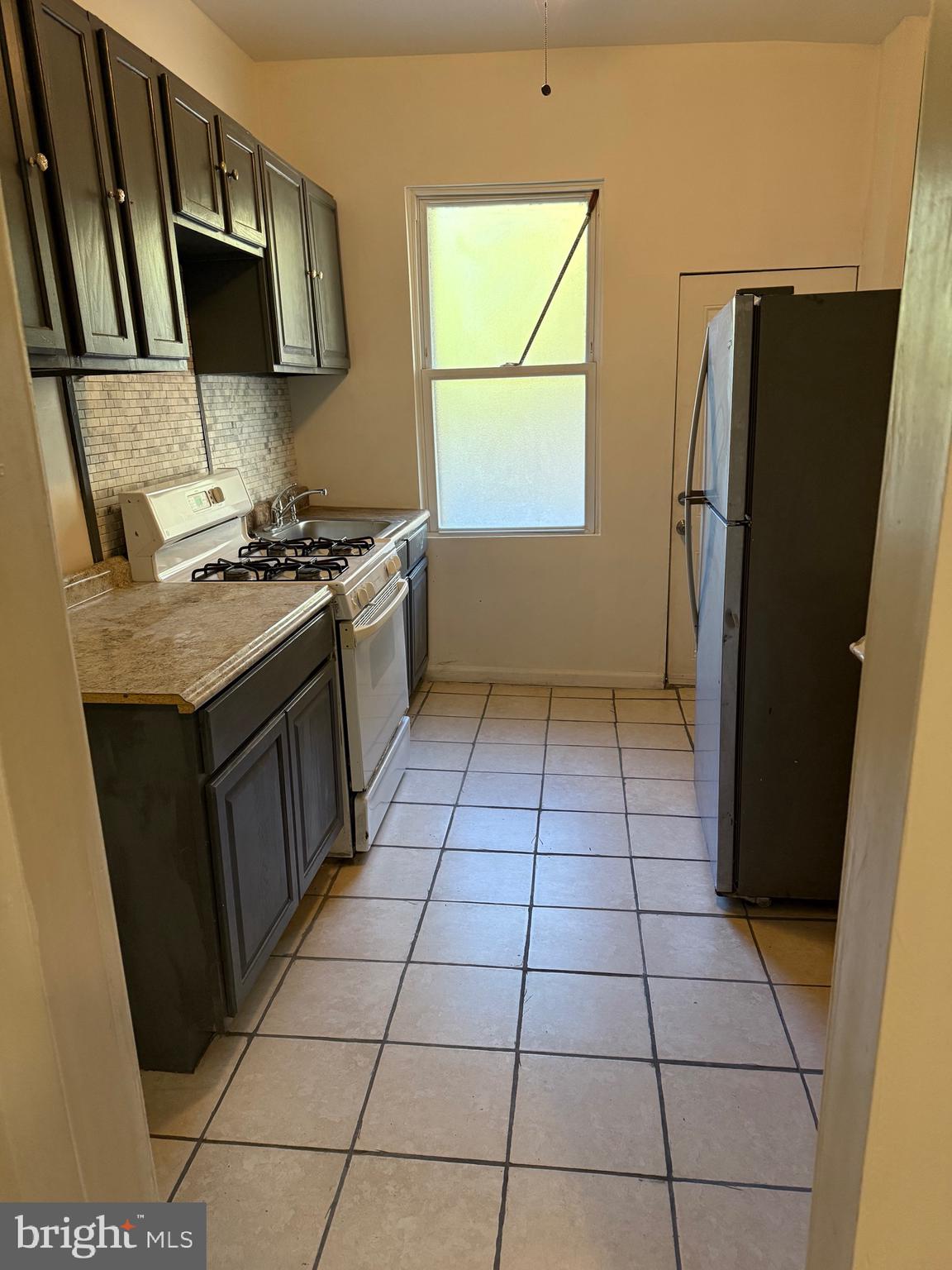 2856 Tulip Street Philadelphia, PA 19134 - Photo 4 of 13 a kitchen with stainless steel appliances granite countertop a stove a refrigerator and a counter top space